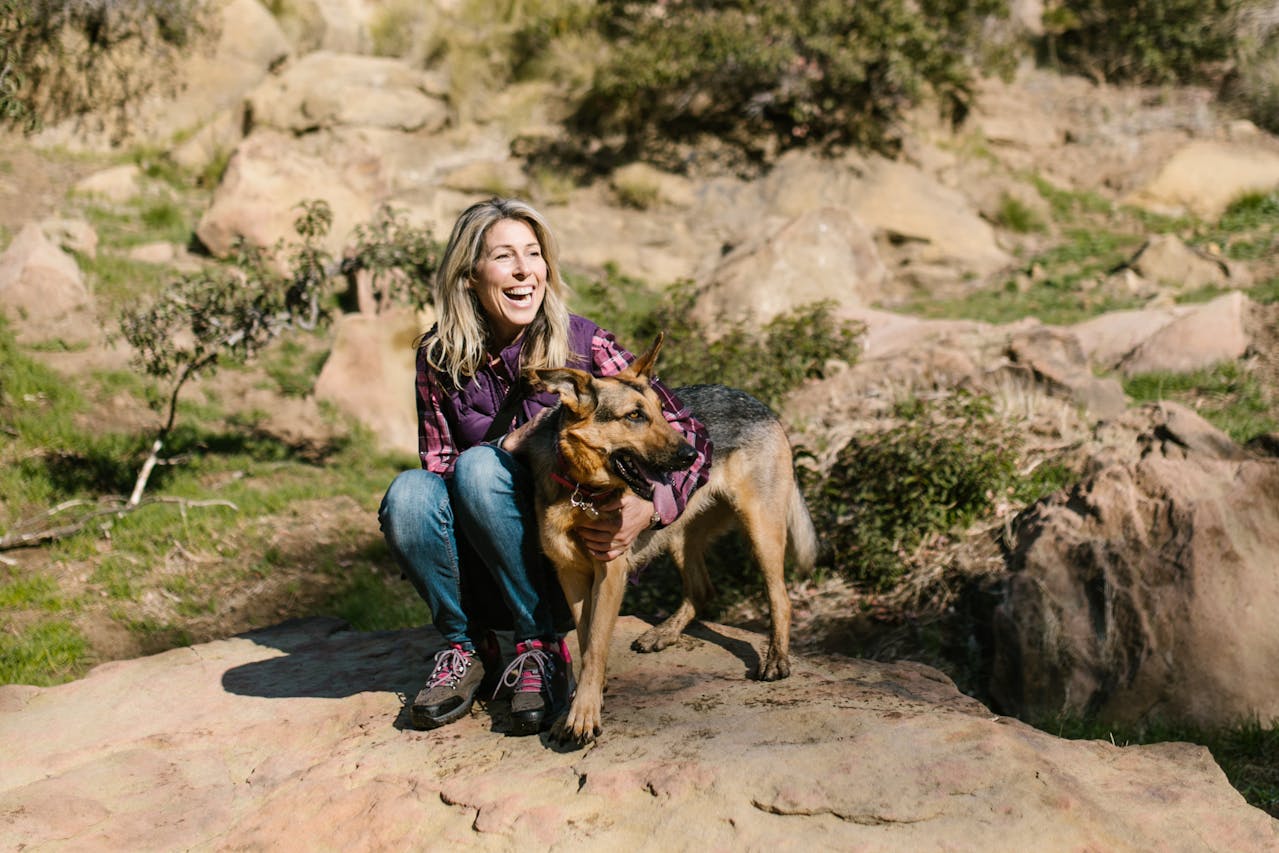 glueckliche-frau-lachend-mit-hund-min